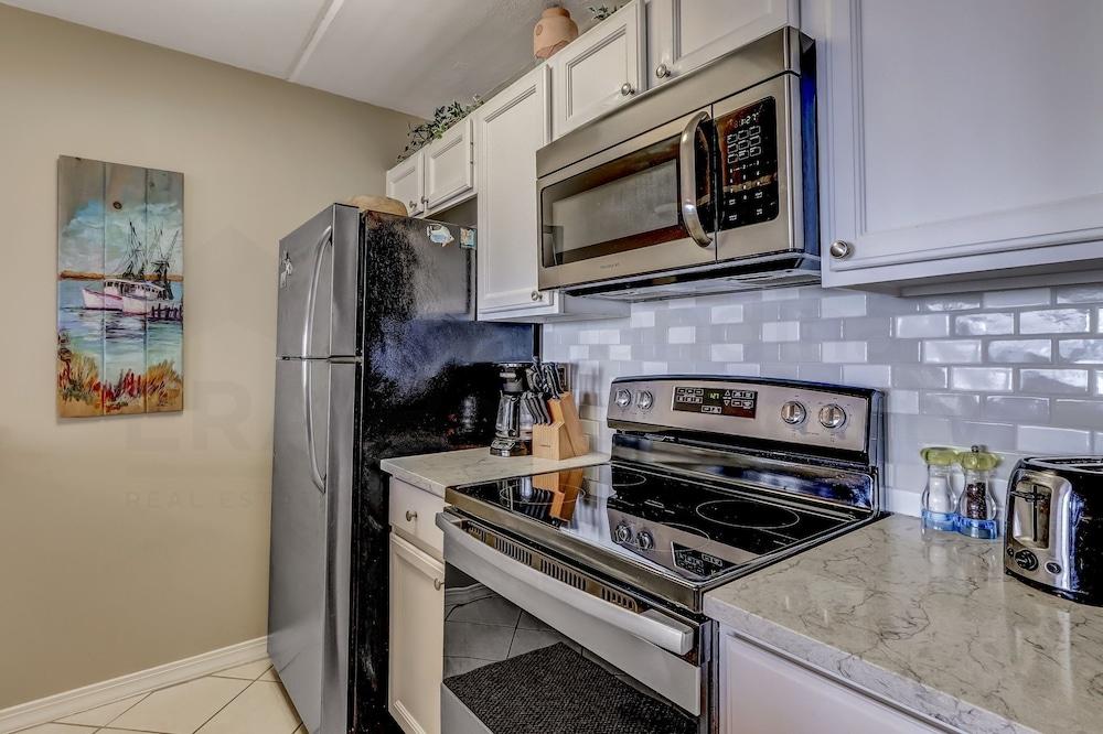 Coast View Condo Featuring Large Windows Overlooking the Beach by RedAwning